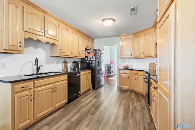 kitchen with dark hardwood / wood-style floors, light brown cabinetry, sink, and black appliances