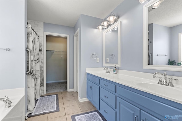 bathroom featuring vanity, tile patterned floors, shower with separate bathtub, and a textured ceiling