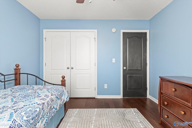 bedroom with dark hardwood / wood-style floors, ceiling fan, and a closet