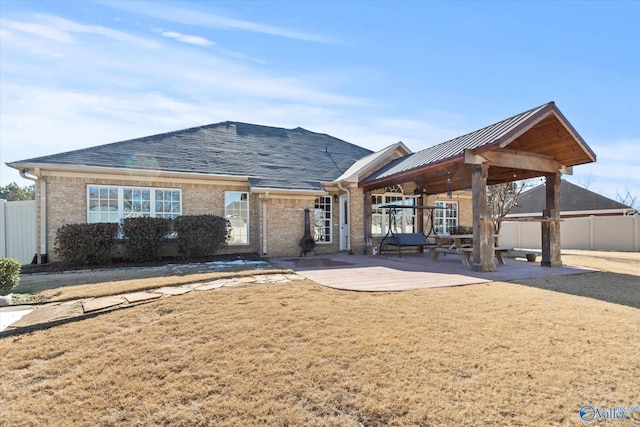 rear view of house featuring a yard and a patio area