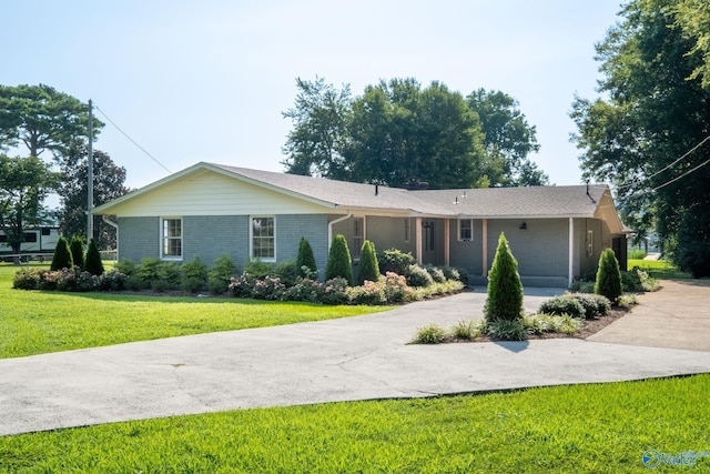 ranch-style home with a front yard, concrete driveway, and brick siding