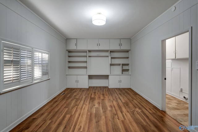 interior space featuring built in desk and wood finished floors