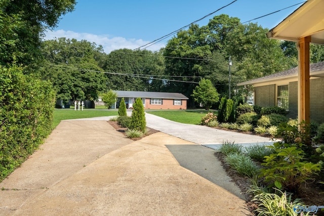 view of community featuring a yard and concrete driveway