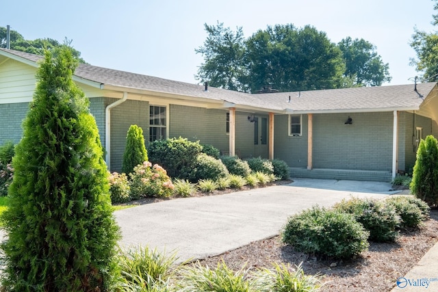 ranch-style house featuring concrete driveway and brick siding