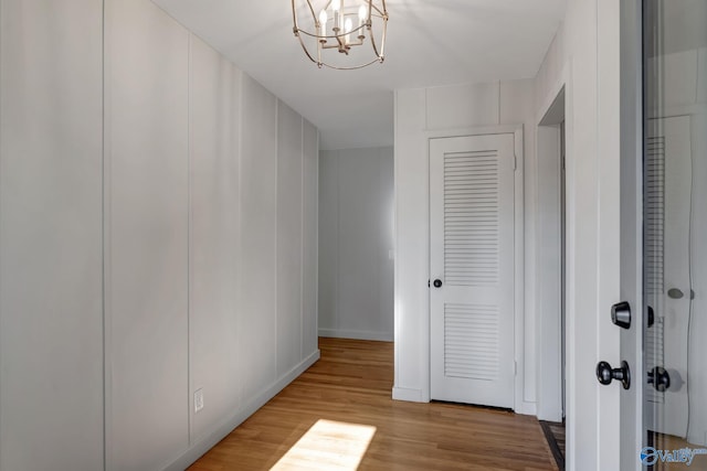 hall with a chandelier and wood finished floors