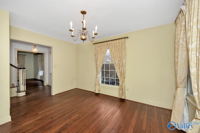 unfurnished room featuring dark hardwood / wood-style floors and a notable chandelier