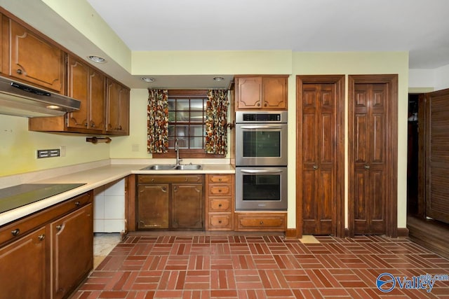 kitchen featuring stainless steel double oven, black electric cooktop, and sink