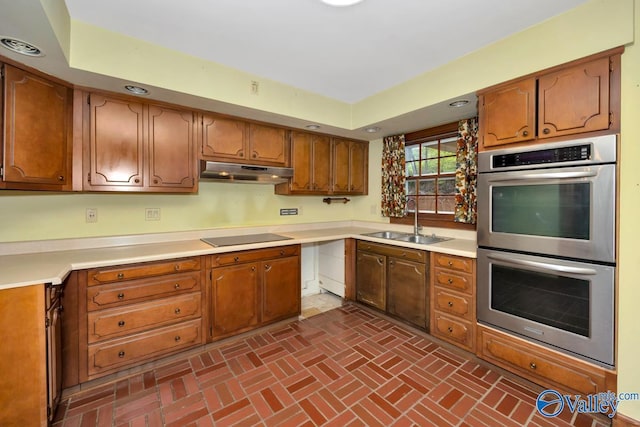 kitchen with black electric stovetop, double oven, and sink