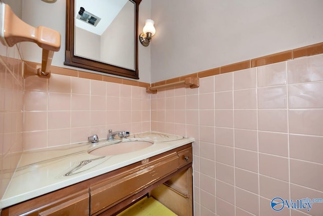 bathroom with vanity and tile walls