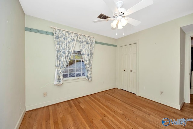 unfurnished bedroom featuring a closet, hardwood / wood-style flooring, and ceiling fan