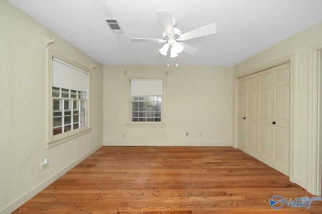 unfurnished bedroom with ceiling fan, light hardwood / wood-style floors, and a closet