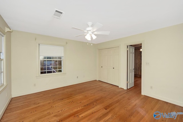 unfurnished bedroom featuring ceiling fan, a closet, and wood-type flooring