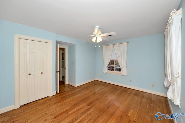 unfurnished bedroom featuring hardwood / wood-style flooring, ceiling fan, and a closet