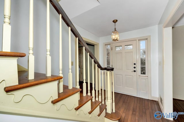 foyer featuring dark wood-type flooring and a notable chandelier