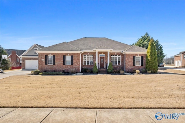 view of front of house featuring driveway, a garage, and brick siding