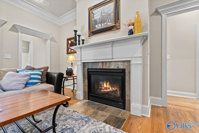 interior space with baseboards, a fireplace, ornamental molding, and wood finished floors