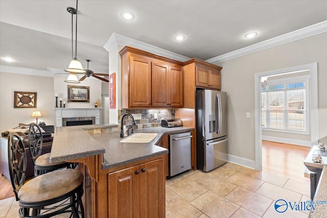 kitchen with crown molding, appliances with stainless steel finishes, brown cabinets, and a sink