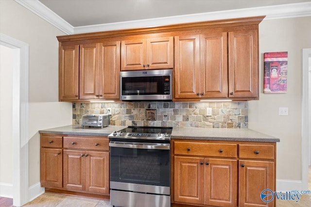 kitchen featuring appliances with stainless steel finishes, brown cabinets, and decorative backsplash