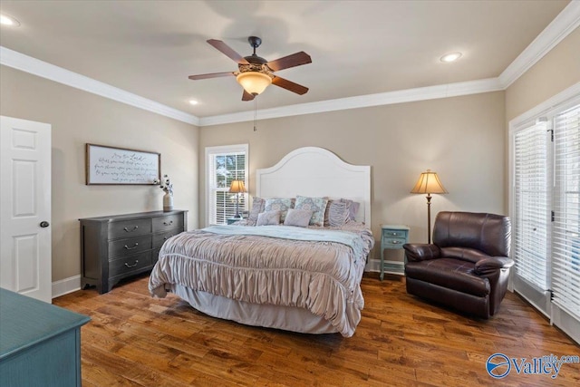 bedroom with baseboards, ornamental molding, and wood finished floors