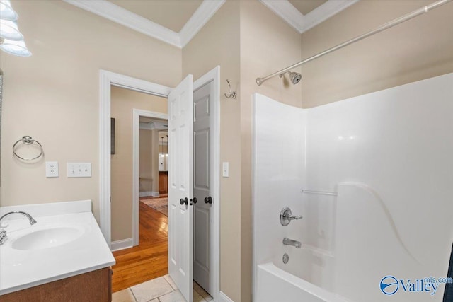 bathroom with tile patterned floors, vanity, washtub / shower combination, and crown molding