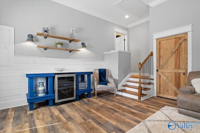 interior space featuring a barn door, recessed lighting, beverage cooler, wood finished floors, and ornamental molding