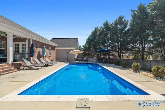 view of swimming pool featuring fence, a fenced in pool, and a patio