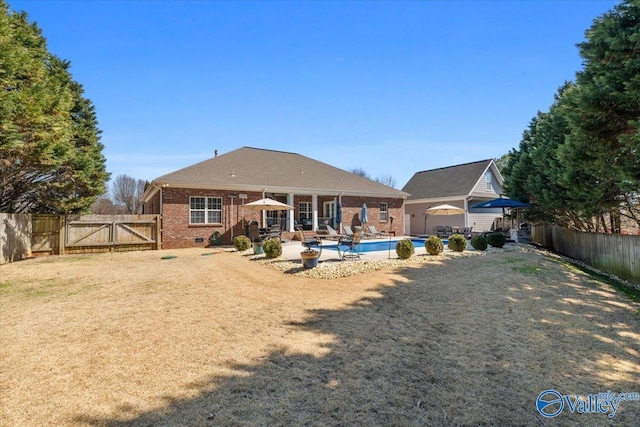 rear view of house featuring brick siding, a patio, crawl space, a gate, and a fenced backyard