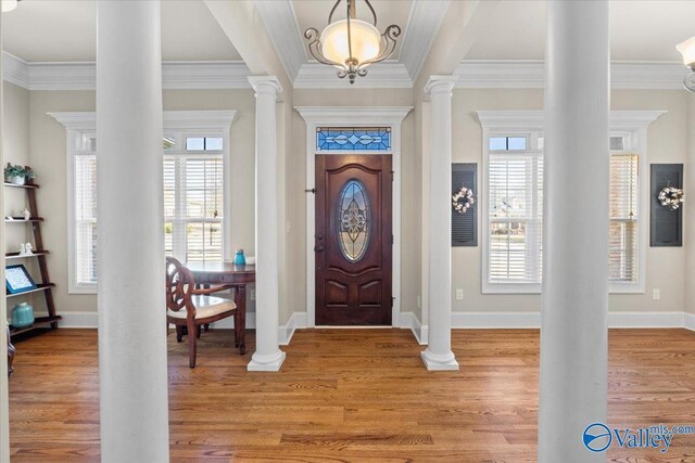 foyer entrance featuring light wood-style floors, baseboards, and ornate columns