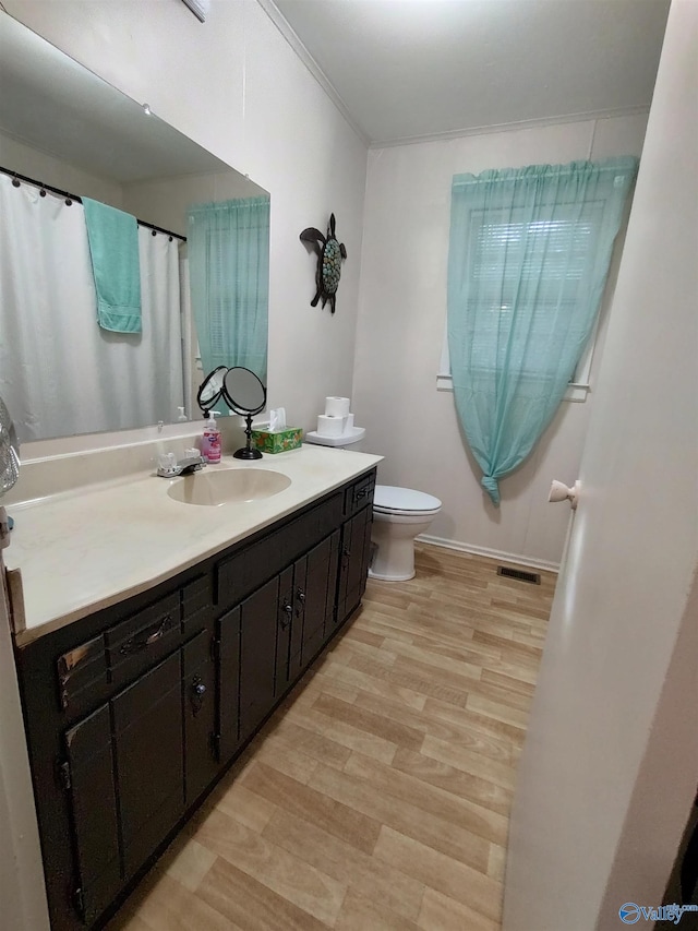 bathroom featuring ornamental molding, vanity, toilet, and hardwood / wood-style flooring