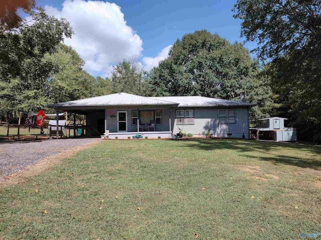 view of front of house with a storage shed, a front lawn, a carport, and a porch