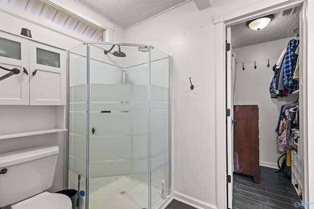 bathroom with wood-type flooring, a shower with shower door, and a textured ceiling