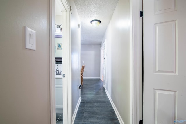 corridor with dark hardwood / wood-style floors and a textured ceiling