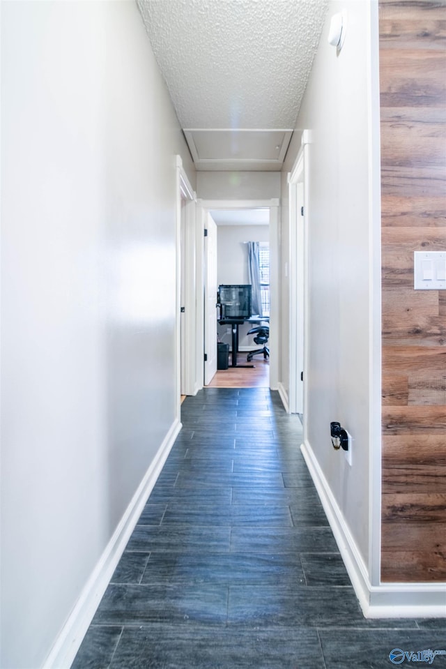 corridor with dark hardwood / wood-style flooring and a textured ceiling