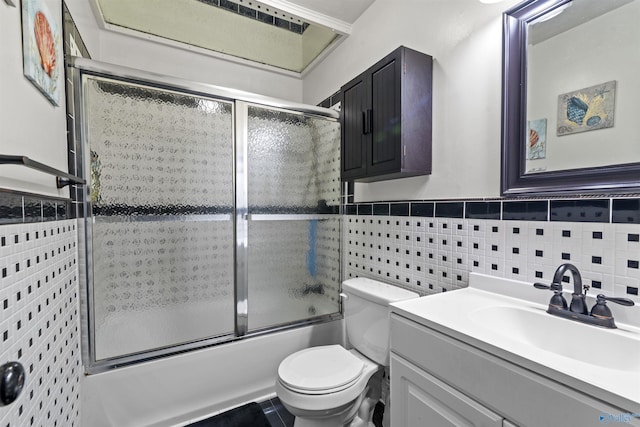 full bathroom featuring tile walls, vanity, bath / shower combo with glass door, and toilet