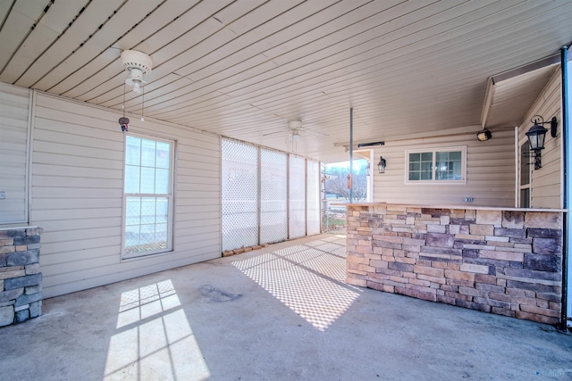 unfurnished sunroom featuring ceiling fan