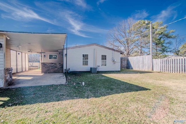 back of property with a yard, a patio, and central air condition unit