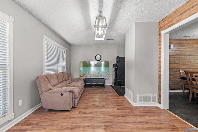 interior space featuring hardwood / wood-style floors, a textured ceiling, and wood walls