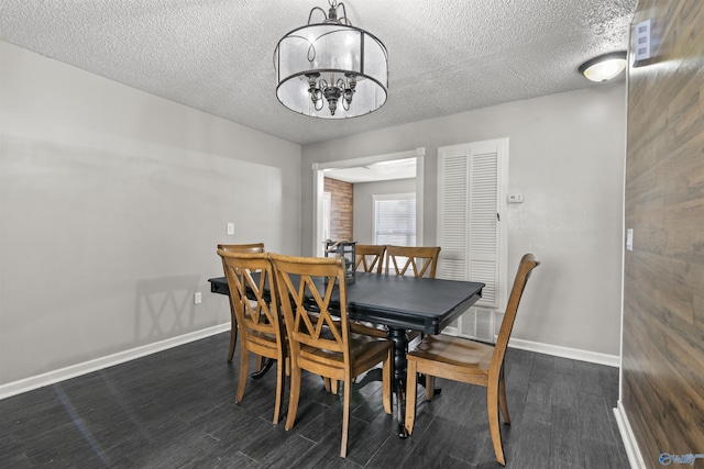 dining area with dark hardwood / wood-style floors, a chandelier, and a textured ceiling