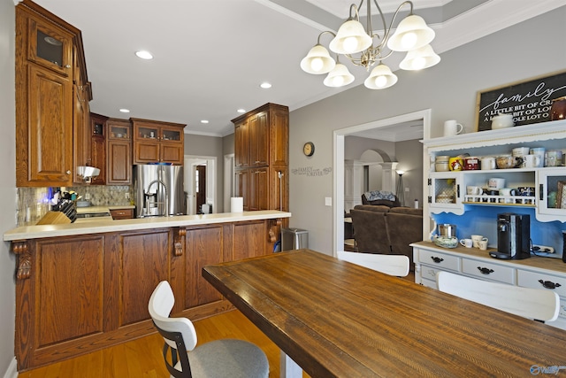 interior space with glass insert cabinets, crown molding, a peninsula, stainless steel refrigerator with ice dispenser, and wood finished floors