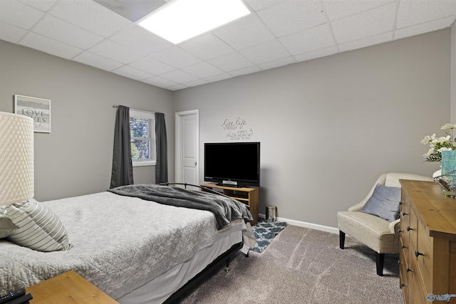 bedroom with a paneled ceiling, baseboards, and carpet floors