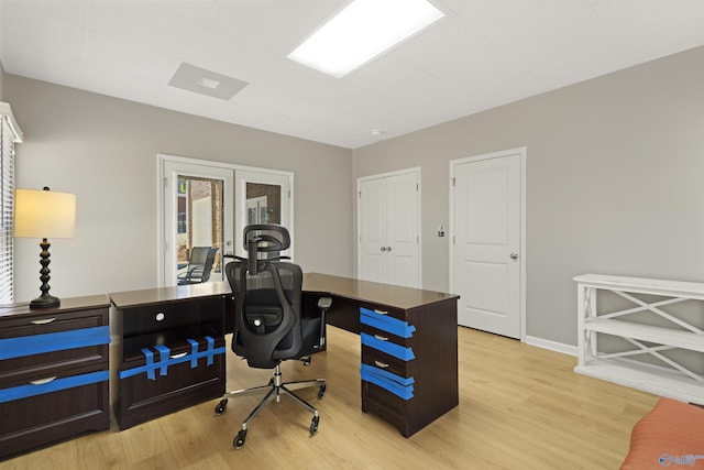 home office with light wood-style floors, baseboards, and french doors