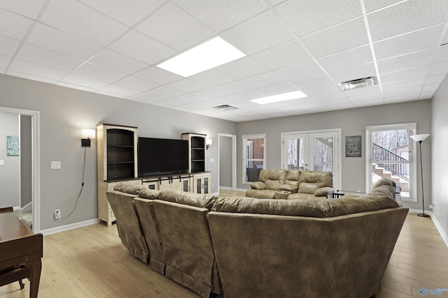 living room with visible vents, baseboards, a drop ceiling, light wood-type flooring, and french doors