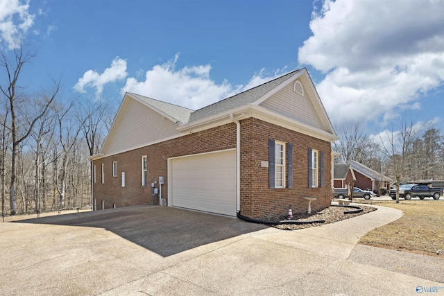 view of property exterior featuring an attached garage, brick siding, driveway, and roof with shingles