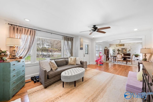 living area featuring a ceiling fan, recessed lighting, baseboards, and light wood-type flooring