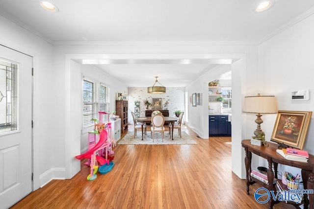 dining area featuring baseboards, light wood-style floors, and ornamental molding