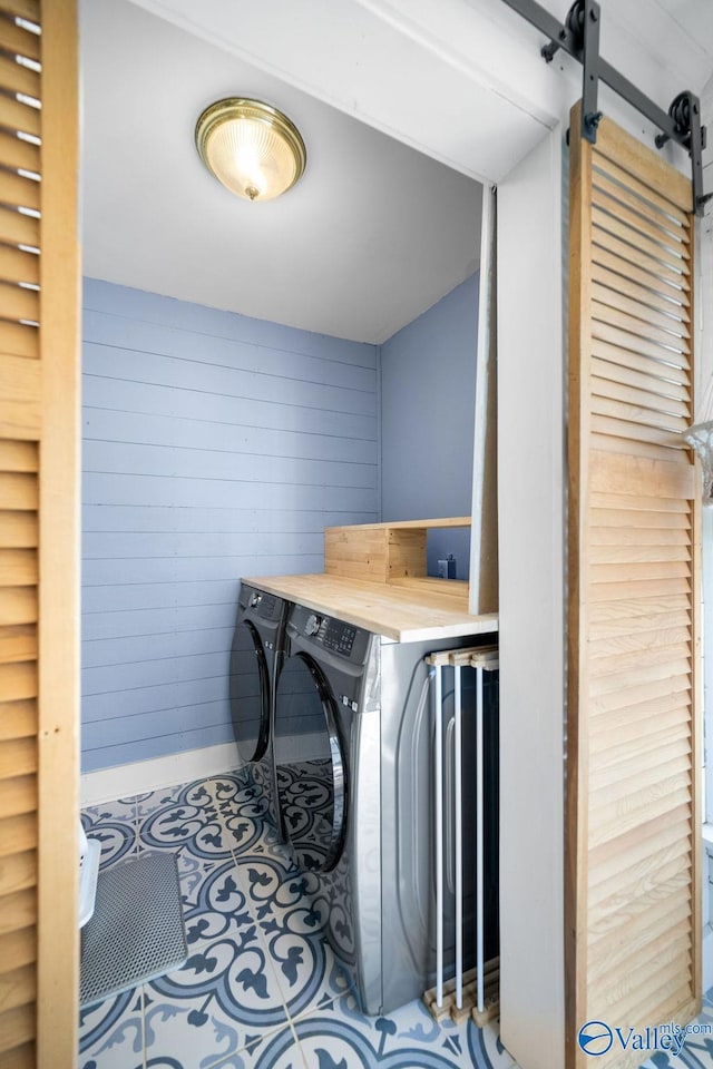 laundry room with tile patterned flooring, laundry area, independent washer and dryer, and wooden walls