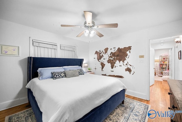 bedroom featuring a ceiling fan, light wood-type flooring, and baseboards