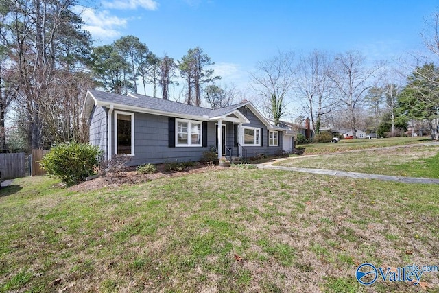 ranch-style home featuring a front lawn and fence