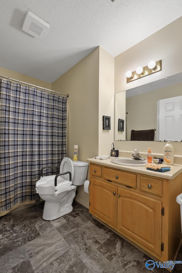 bathroom featuring toilet, a textured ceiling, curtained shower, and vanity