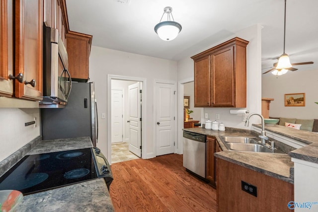 117 Somerset Park Dr NE, Huntsville, AL 35811 - kitchen featuring stainless steel appliances, dark countertops, a sink, and brown cabinetry